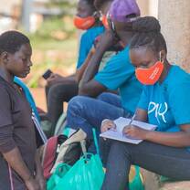 Volunteers handing out play items to kid
