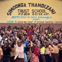 Volunteer cheering with children outside Simoonga. 