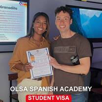 Student holding OLSA diploma with teacher