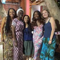 4 female students gathered together at a restaurant with the APA Dakar program director in Senegal