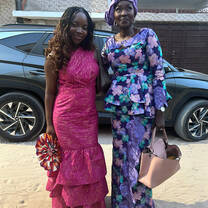 Female student in pink dress with host mother in purple dress ready to go to a wedding in Dakar Senegal