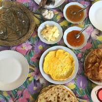 Several plates laid out on a table with a colorful cloth as part of a breakfast in Morocco. 