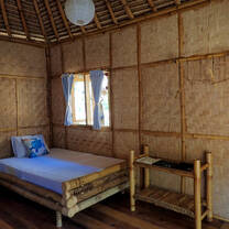 Inside one of our huts! We took the mosquito net down to show the bed clearly but each room comes with a net, fan, lamp, cushions, pillows, shelves and hangers.