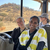 Two volunteers smile in the back of a safari truck