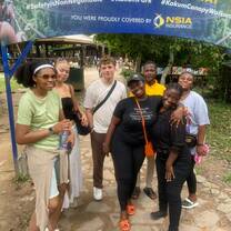 Volunteers gather with their coordinators under a sign that reads 'I Survived the Kakum Canopy Walkway'