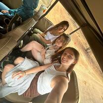 Three volunteers take a selfie in the back of a safari truck
