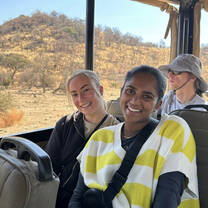 Two volunteers smile in the back of a safari truck
