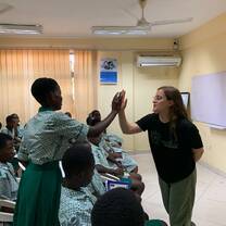 Volunteer and student give me a high five
