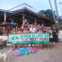 a grou poses for a photo with a banner that reads beach clean up