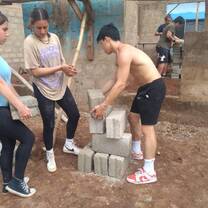 Construction volunteers arrainging bricks