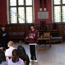 Three students presenting in the Oxford Union