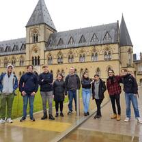 Students stand in front of historic building, the natural history museum in Oxford, England