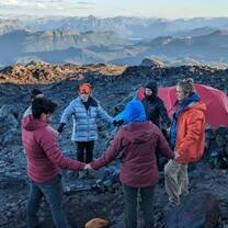 Crew circles up on a rocky summit