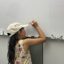Student writing at board