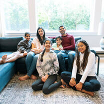 Au pair sitting with host family in the living room