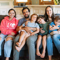 Au pair sitting on couch with host family