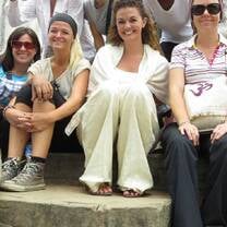 A group of international interns sitting on stone steps, smiling during their time in Nepal.