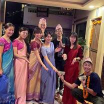 Interns dressed in traditional Nepali clothing for a cultural celebration indoors.