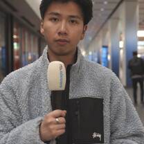 Media intern with microphone filming news segment