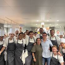 Group shot of kitchen staff posing with chef's hats