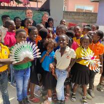 Volunteers with students showcasing upcycled creations