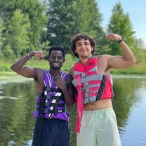 Camp USA participant smiling triumphantly on the lake shore