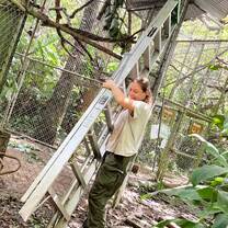 A volunteer has a huge smile on her face as she carries a ladder through our pre-release area