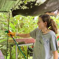 Volunteer using a hose to clean our pre-release area