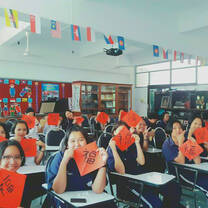 International student practicing Chinese calligraphy and writing red couplets at RPL School