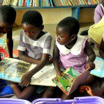 Children enjoying reading and literacy games at GHEI's community library in Humjibre