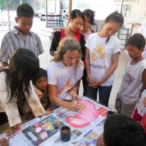 Girl painting with kids in Cambodia