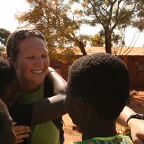 Volunteer hugging students