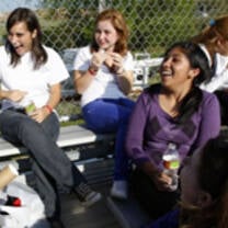 Students laughing sitting in a bench