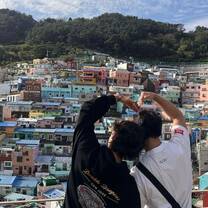 Students making heart hands over Busan skyline