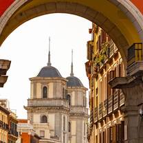 Red archway looking out on historic building in Spain