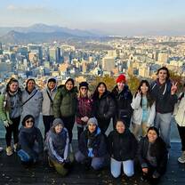 Seoul student group posing with skyline behind them