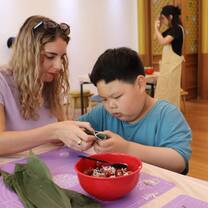 Aupair and host child making traditional festival food 