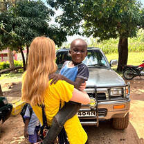 Volunteer holding a child at Korando
