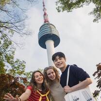 EF Gap Year students smile for a selfie beneath Seoul’s iconic Namsan Tower, soaking up city views, new friendships, and K-culture energy.