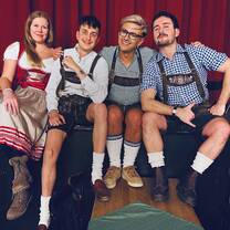 EF Gap Year students in Munich wearing traditional Bavarian lederhosen and dirndls, smiling together while experiencing local culture.