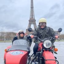 EF Gap Year students in Paris on a retro motorcycle and sidecar tour in front of the Eiffel Tower, experiencing the city in a fun and unique way.