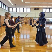 CET Japan students lined up at one side and another person in uniform at a kendo workshop