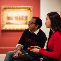 Students sitting in a museum. 