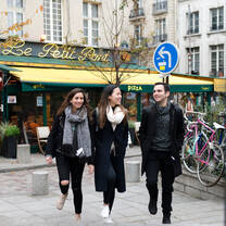 Students stand in front of a cafe. 