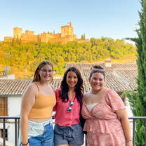 Girls pose for photo in front of castle in Spain