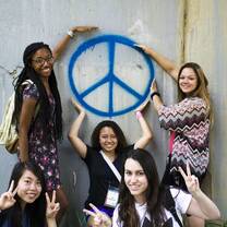 Group of students pointing to a peace sign