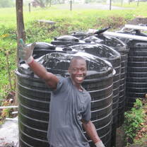 Volunteer standing by water collection system