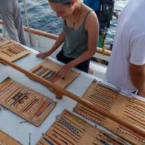 Student looking at bracelets brought to the ship by merchants on small boats