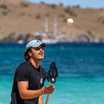 Students playing lacrosse on Komodo island beach