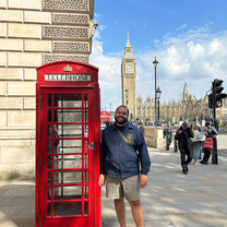 Man standing beside a British red telephone box